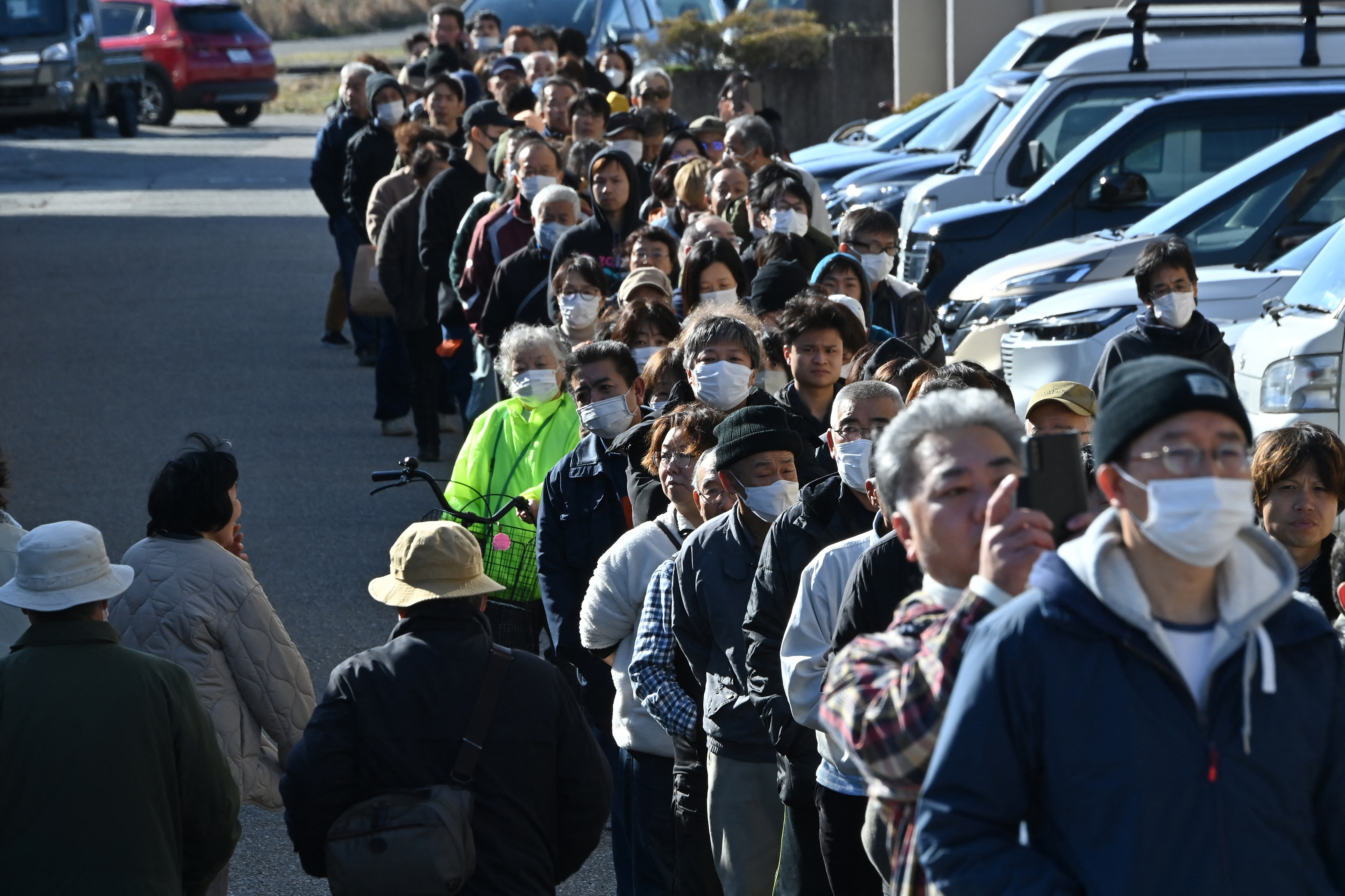 Cientos de habitantes de la pequeña ciudad japonesa de Shika hacen fila el martes frente a la alcaldía esperando recibir los seis litros de agua asignados a cada persona tras el potente terremoto que sacudió en la víspera el país.