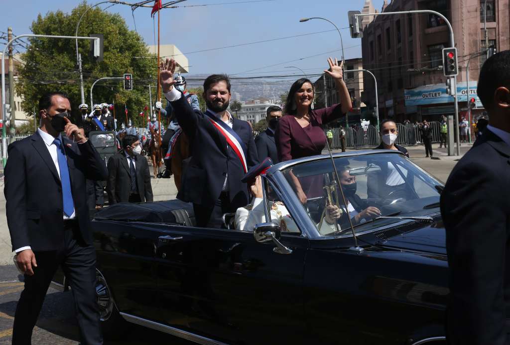 AME2474. VALPARAISO (CHILE), 11/03/2022.- El presidente de Chile, Gabriel Boric (I), junto a la ministra del Interior, Izkia Siches (d), saludan a bordo del vehículo presidencial Ford Galaxie donado por la reina Isabel II de Ingalterra, mientras reciben honores de las Fuerzas de Armadas tras ser investido en la sede del Congreso Nacional hoy en Valparaíso (Chile). El progresista Gabriel Boric asumió este viernes la Presidencia de Chile en una solemne ceremonia en la ciudad costera de Valparaíso a la que acudieron parlamentarios de todos los partidos y un nutrida representación de jefes de Estado y de Gobierno de todo el mundo. En el Salón de Honor del Senado, el nuevo presidente de la cámara, el socialista Álvaro Elizalde, le impuso la banda presidencial a Boric, que con apenas 36 años y un mes se convierte en el mandatario más joven de la historia del país. EFE/Elvis González