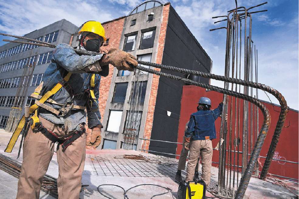 Obrero sujetando unas varillas en una construcción en Bogotá