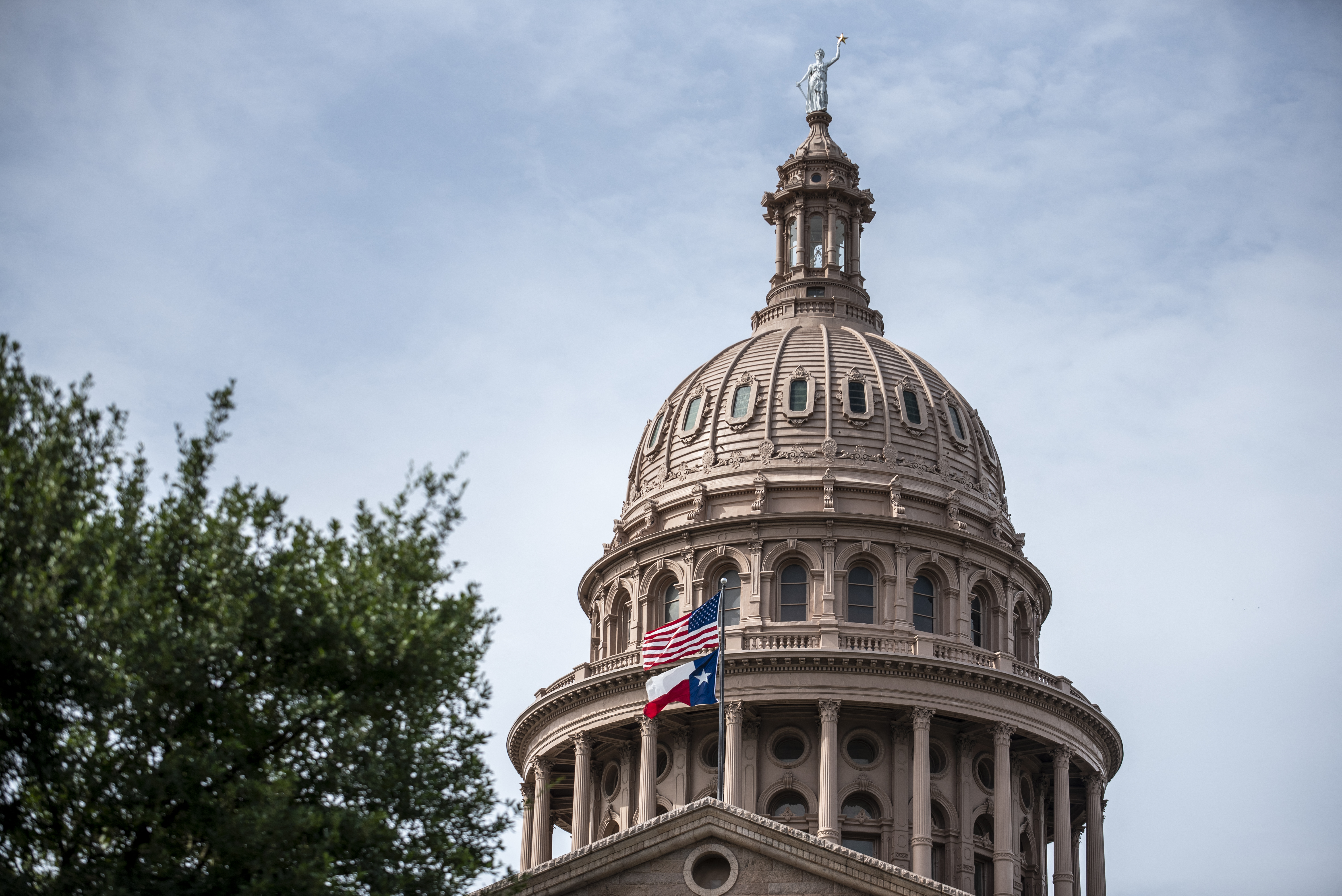 Las banderas estatales de Estados Unidos y Texas ondean fuera del edificio del Capitolio estatal