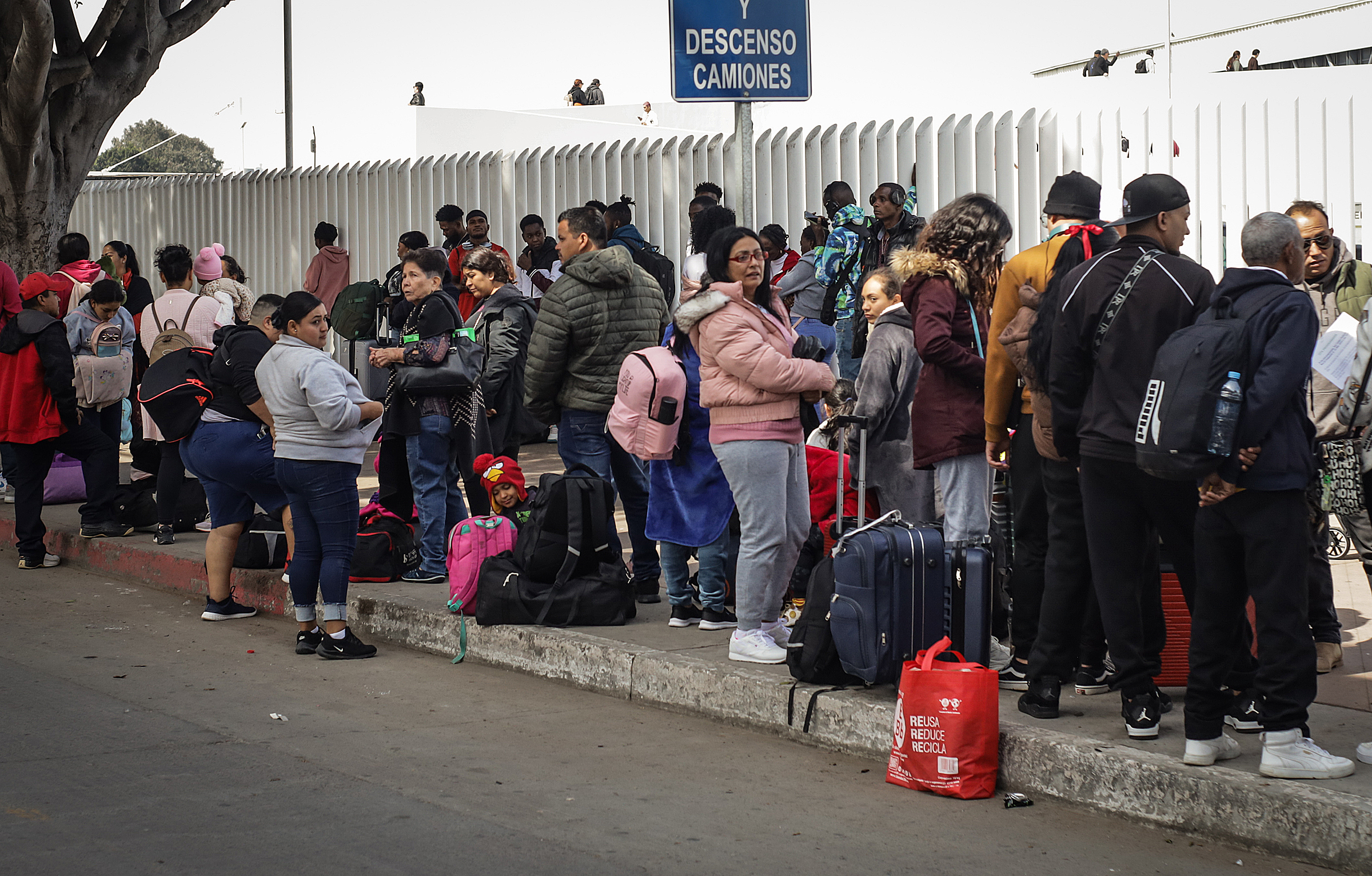 MEX2912. TIJUANA (MÉXICO), 26/03/2024.- Migrantes hacen fila para solicitar un proceso de asilo en Estados Unidos, el 23 de marzo de 2024, en el paso fronterizo del Chaparral en Tijuana, Baja California (México). La organización Border Line Crisis Center en Tijuana, en la frontera norte de México, exigió este martes una investigación profunda tras el arresto y posterior liberación la semana pasada de dos agentes del Instituto Nacional de Migración (INM) acusados de corrupción y trata de personas. EFE/Joebeth Terriquez