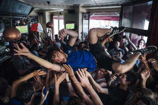 People react as they gather on July 15, 2018 to watch the Russia 2018 World Cup final football match between France and Croatia, in the "Le Carillon" bar where the attacks of November 2015 took place in Paris.
/ AFP PHOTO / Lucas BARIOULET