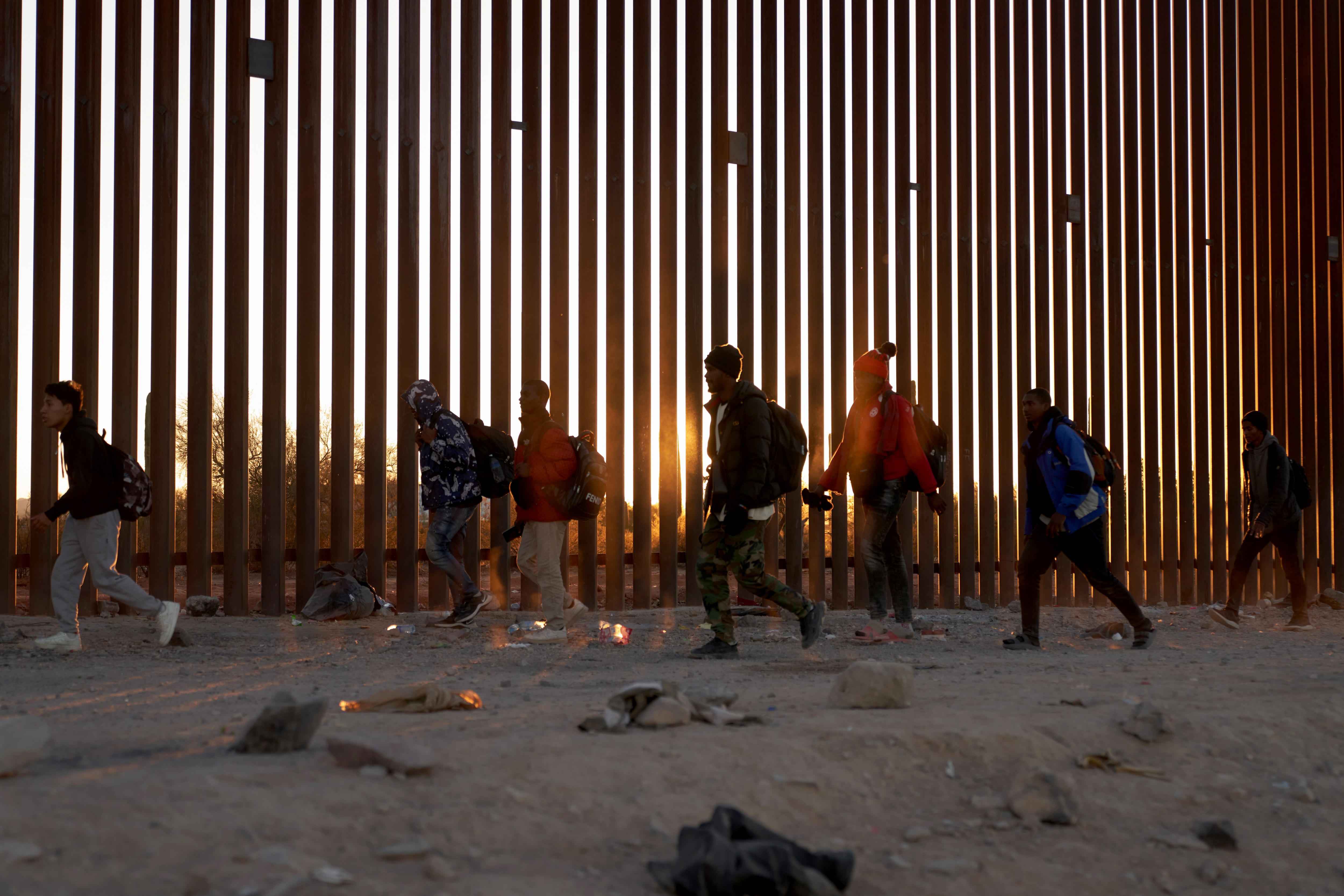 Lukeville (United States), 12/12/2023.- Migrants walk along the US border wall looking for US Border Patrol in Lukeville, Arizona, USA, 12 December 2023. The United States is currently seeing the largest surge of migrants entering the country in the history of US Border Patrol. In response, Senate Republicans are blocking the advancement of a $110 billion package of wartime funding for Ukraine and Israel until US President Joe Biden agrees to include changes to the US border policy. (Ucrania, Estados Unidos) EFE/EPA/ALLISON DINNER