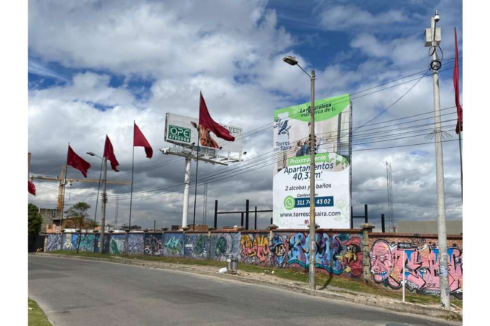 Mural de la calle 161 con séptima. Sobre el andén se ven unas banderas rojas izadas.