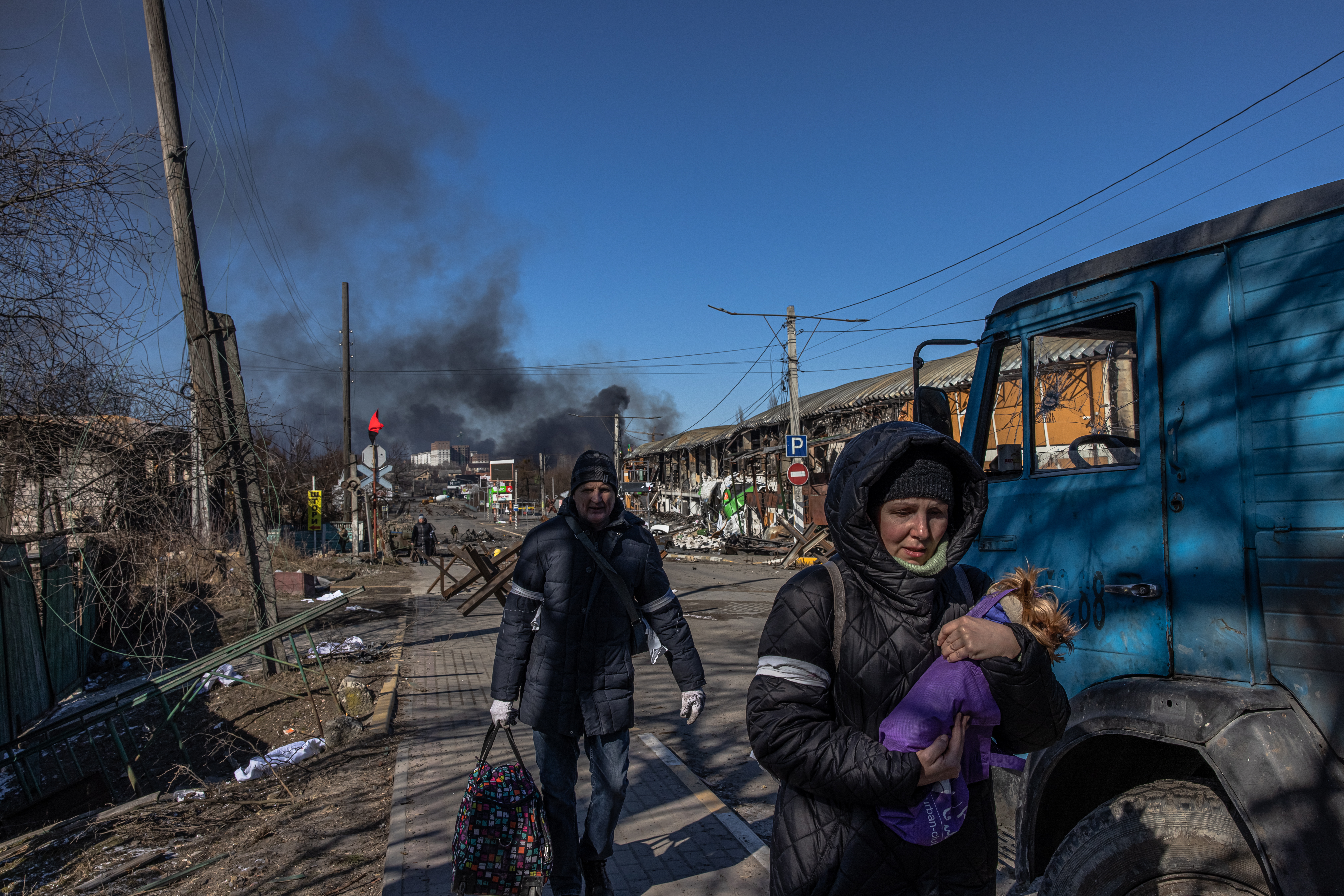 Kyiv (kiev) (Ukraine), 10/03/2022.- Residents coming from Bucha town, which is currently controlled by the Russian military, walk with luggage past the Ukrainian checkpoint at the frontline in Irpin town, Kyiv (Kiev) region, Ukraine, 10 March 2022. Thousands of residents are feeling Irpin and Bucha, as well as other settlements near Kyiv which were the most affected by the Russian army invasion. (Rusia, Ucrania, Estados Unidos) EFE/EPA/ROMAN PILIPEY