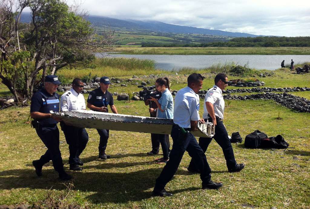 (FILES) Police carry a piece of debris from an unidentified aircraft found in the coastal area of Saint-Andre de la Reunion, in the east of the French Indian Ocean island of La Reunion, on July 29, 2015. The two-metre-long debris, which appears to be a piece of a wing, was found by employees of an association cleaning the area and handed over to the air transport brigade of the French gendarmerie (BGTA), who have opened an investigation. An air safety expert did not exclude it could be a part of the Malaysia Airlines flight MH370, which went missing in the Indian Ocean on March 8, 2014.