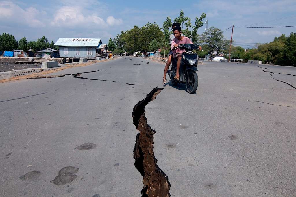 MBAY (Indonesia), 15/08/2026.- A motorcyclist rides past a crack on the road following a 7.7 magnitude earthquake in Mbay, Nagekeo, East Nusa Tenggara Province, Indonesia, 15 August 2026. A 7.7 magnitude earthquake struck off the coast of Indonesia's East Nusa Tenggara province, leaving scores of people dead and triggering a minor tsunami. (Terremoto/sismo) EFE/EPA/IGNASIUS KUNDA