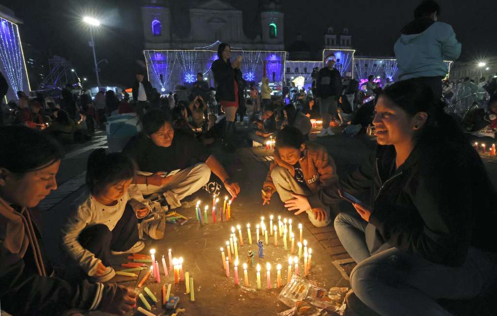 AME4042. BOGOTÁ (COLOMBIA), 07/12/2024.- Personas encienden velas durante la tradicional Noche de las Velitas este sábado en Bogotá (Colombia). La tradicional Noche de las Velitas, que marca el inicio de la Navidad en Colombia, se vivió este sábado en el que familias a lo largo y ancho del país se reunieron en viviendas, edificios, plazas y parques para compartir comida y golosinas y disfrutar de los alumbrados navideños. EFE/Mauricio Dueñas Castañeda