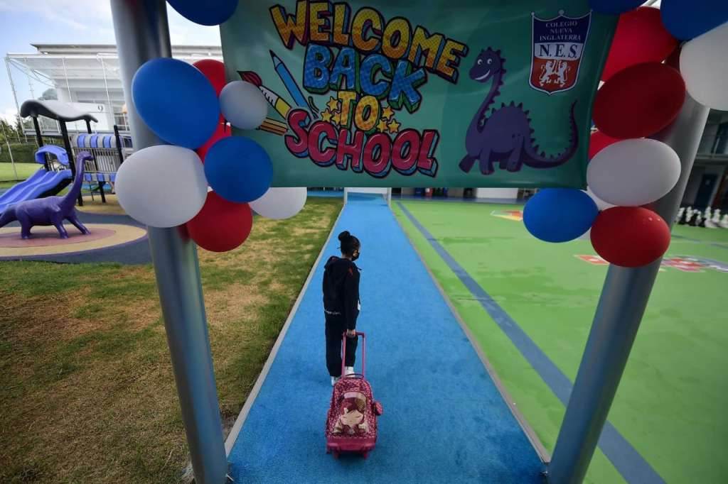 una niña entrando al colegio por un pasillo.