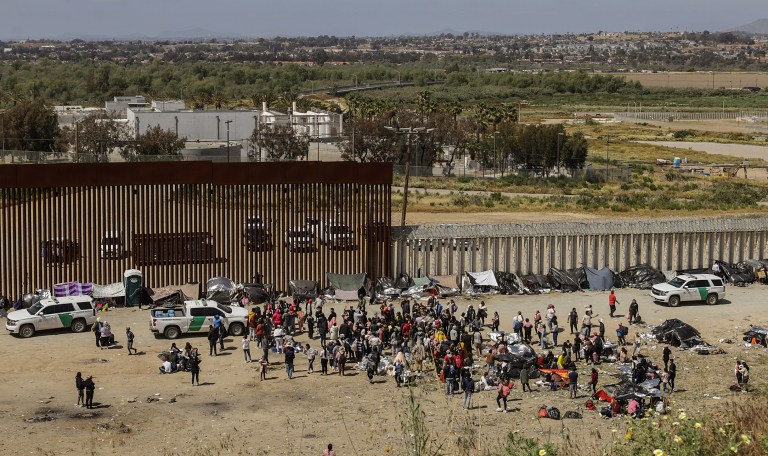 MEX4646. TIJUANA (MÉXICO), 10/05/2023.- Fotografía general donde se observa a migrantes en un campamento junto al muro fronterizo, el 9 de mayo de 2023, en Tijuana, Baja California (México). Tan solo en Tijuana, en la frontera con California, miles de migrantes de diversas nacionalidades, incluyendo familias completas y niños se congregan entre los muros fronterizos días antes de que culmine el Título 42, la noche del jueves, para pedir asilo humanitario en Estados Unidos. El campamento ha ido creciendo desde el fin de semana pasado con personas de Colombia, Venezuela, Perú, Haití, y Honduras, pero también de países lejanos como Turquía y Bosnia, así como mexicanos de los estados sureños de Michoacán y Guerrero, donde la violencia del crimen organizado los desplaza.EFE/Joebeth Terriquez