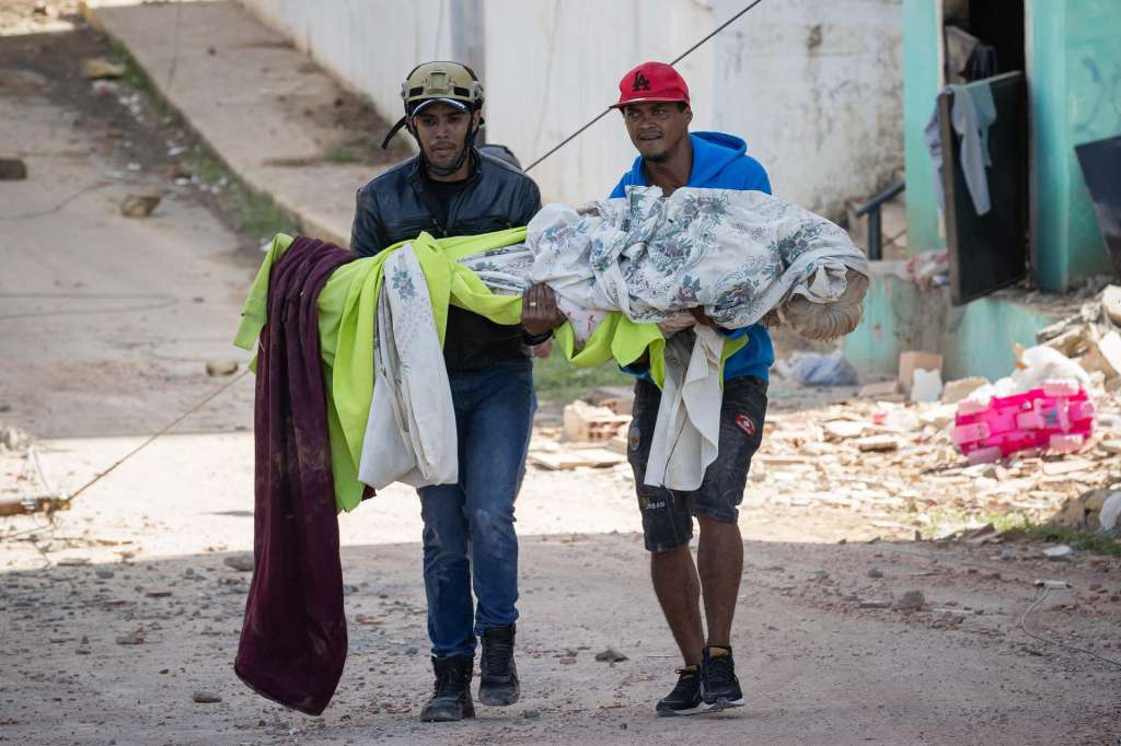 AME4386. CATIA LA MAR (VENEZUELA), 25/06/2026.- Voluntarios rescatan víctimas mortales este jueves, en Catia La Mar (Venezuela). El número de fallecidos en Venezuela a causa de los dos terremotos del miércoles se elevó a 188 y el de heridos a 1.520, mientras que al menos 346 construcciones, entre edificios, hospitales y centros comerciales, resultaron afectadas, informó el presidente de la Asamblea Nacional (AN, Parlamento), el chavista Jorge Rodríguez. EFE/ Ronald Peña R.
