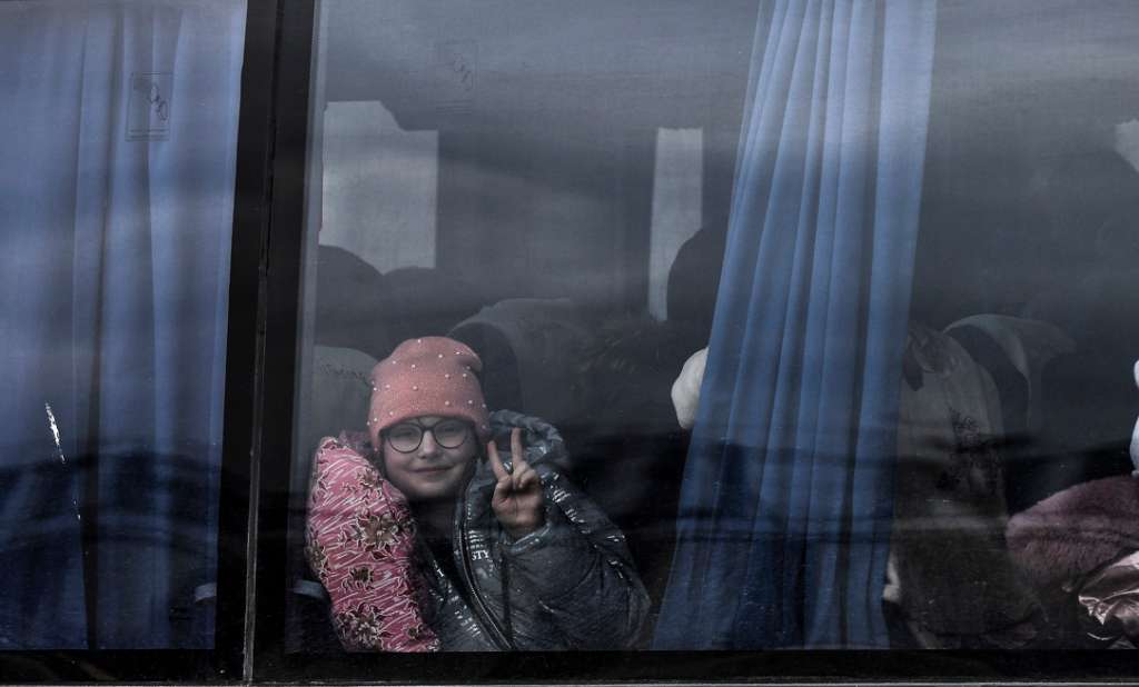 Una niña hace el signo de la victoria desde un autobús en el que ha llegado a Zaporiyia. Esta ciudad del centro este de Ucrania se ha convertido en el lugar al que llegan la mayor parte de personas que huyen de Mariúpol y las localidades cercanas controladas por el ejercito ruso.
