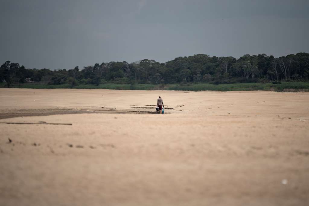 AME4589. MANACAPURU (BRASIL), 03/10/2024.- Un hombre camina en la arena a la orilla del río Solimões, este jueves en la región de Manacapuru, Amazonas (Brasil). El río Negro, uno de los mayores afluentes del río Amazonas, alcanzó mínimos históricos marcando 12,68 metros este jueves, informó el Servicio Geológico Brasileño (SGB).  Lo mismo ocurre con el río Solimões, cuyas aguas convergen con el Negro, y en septiembre alcanzó el nivel más bajo registrado en una ciudad fronteriza con Colombia. EFE/ Raphael Alves