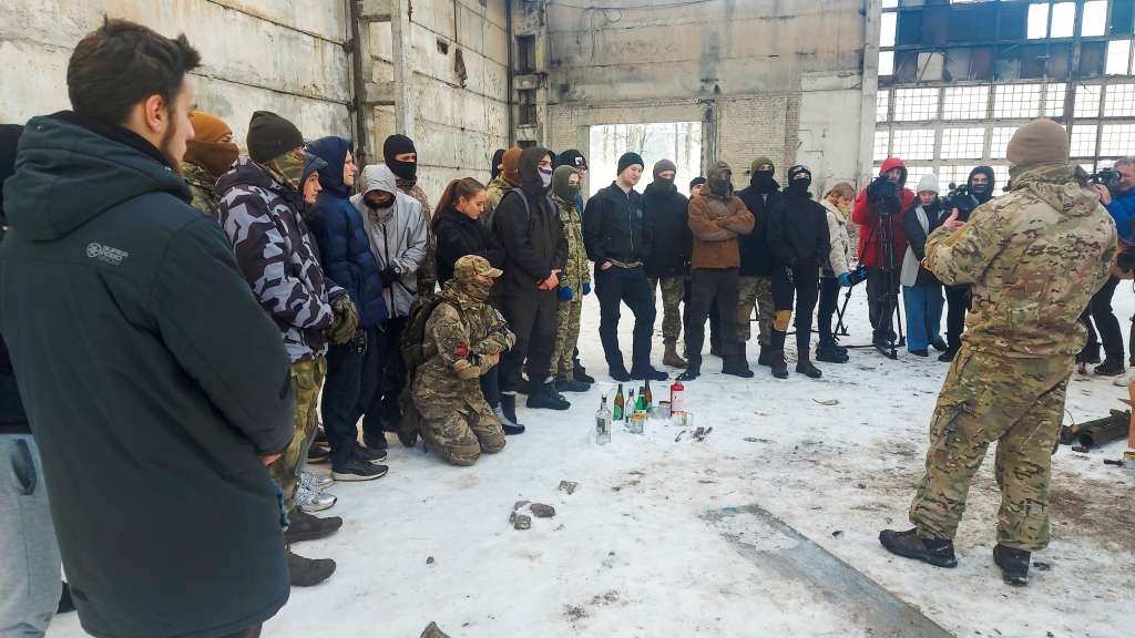 KIEV, 07/02/2022.- Varios cientos de civiles ucranianos armados con fusiles de madera juegan a la guerra en las ruinas de una antigua fábrica de tractores en Kiev, donde aprenden los rudimentos de la defensa de la ciudad en caso de invasión rusa. A la fábrica ATEC, convertida en centro de entrenamiento del batallón ultranacionalista Azov, formación paramilitar que combatió contra las milicias prorrusas en el este del país y ahora está integrada en el Ejército, acuden más de quinientos hombres y mujeres.- EFE/Fernando Salcines