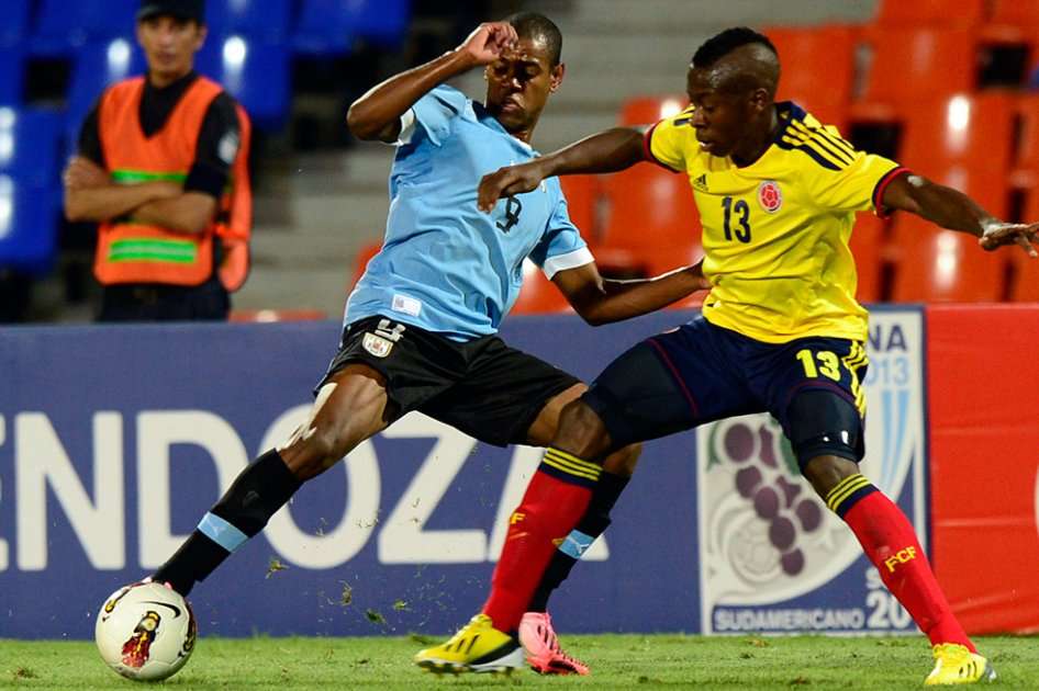 El jugador colombiano Helibelton Palacios intenta controlar a Diego Rolan de uruguay. / AFP