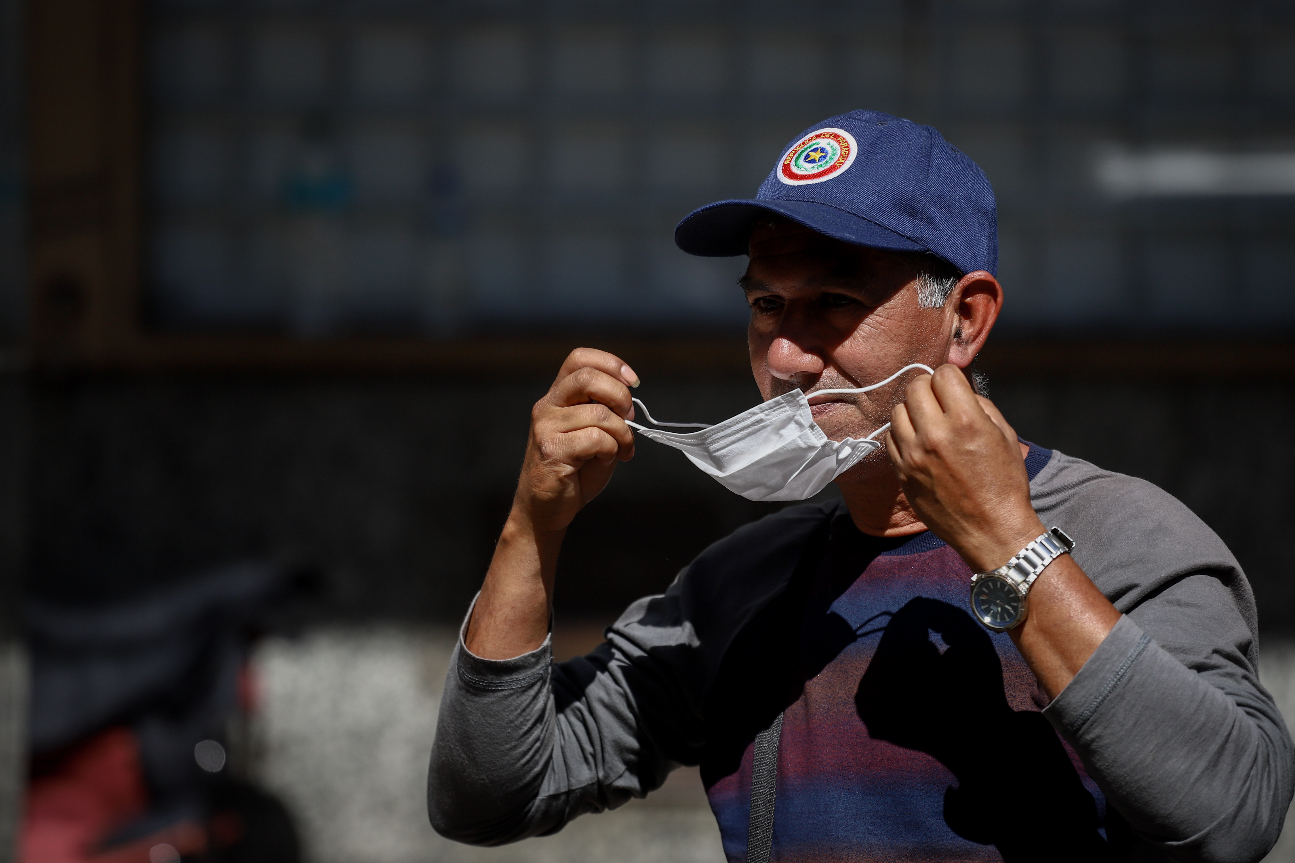 AME2159. ASUNCIÓN (PARAGUAY), 18/04/2022.- Una persona se pone un tapabocas hoy, en Asunción (Paraguay). El Gobierno de Paraguay levantó este lunes la emergencia sanitaria vigente desde marzo de 2020 por la pandemia, con lo que puso fin al uso obligatorio de la mascarilla ante el descenso de los contagios y muertes por el virus. EFE/ Nathalia Aguilar