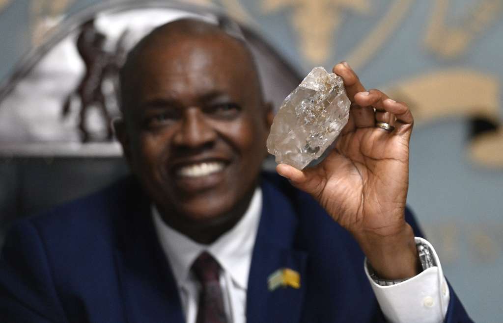 Botswana's President Mokgweetsi Masisi holds a large diamond discovered in Botswana at his office in Gaborone on August 22, 2024.