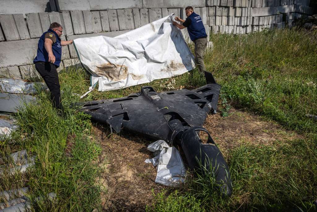 Fiscales ucranianos de crímenes de guerra con un dron ruso del tipo Shahed, en la región ucraniana de Járkov el año pasado. Aunque Irán inicialmente suministró cientos de drones en 2022, Rusia construyó después su propia planta de producción y evolucionó el diseño.