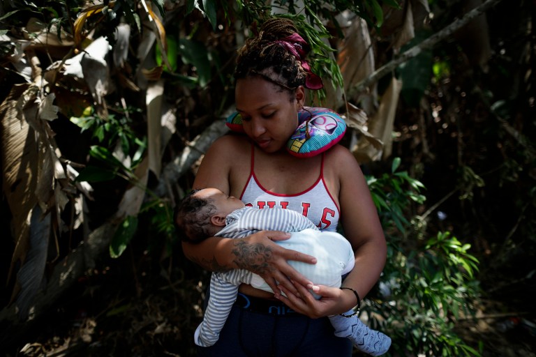 -FOTOGALERÍA- AME4250. BAJO CHIQUITO (PANAMÁ), 21/03/2023.- Ana Teresa Rodríguez, una venezolana de 26 años, carga a su hijo Aquiles Cedeño de 2 meses mientras esperan para ser trasladados en canoa desde la Quebrada León hasta a la comunidad de Bajo Chiquito, el 10 de marzo de 2023, en Darién (Panamá). "Guerreros", repiten las madres, hijos guerreros que han aguantado largas caminatas, hambre, sed, el calor, picaduras de insectos, superar ríos y cerros, para sobrevivir a la selva del Darién en su ruta hacia Estados Unidos. La venezolana Ana Rodríguez también está con su bebé en brazos, que duerme. Durante la selva lo cargó "un ratico" ella, otro su esposo, un amigo. "Hay gente que te ayuda, como hay gente que no tiene fuerza para ayudarte". "Aquí hay mujeres embarazadas, niños, pero no es fácil, lo que se vive adentro no es fácil. Nada más cuando cae la noche, la expectativa de que tus hijos no se enfermen, porque se mojan. Que uno no se enferme, lo que uno ve allá adentro, carpas cerradas con gente adentro muerta. Se ven muchas cosas: travesía, hueco, río hondo, gente ahogándose. Es algo, una experiencia para toda la vida, por una mejoría, porque es la única manera", afirma a EFE Rodríguez. EFE/ Bienvenido Velasco