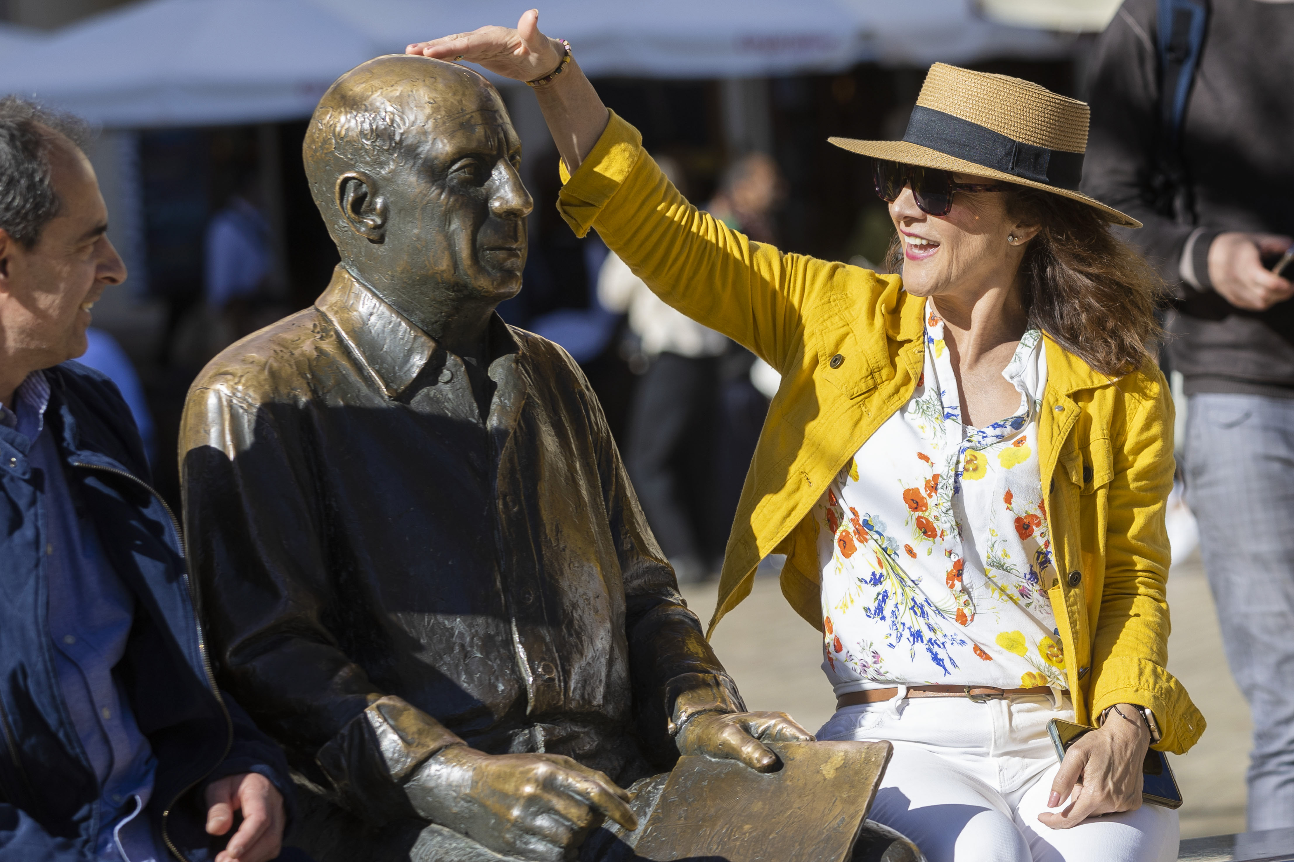 -FOTODELDÍA- MÁLAGA, 08/04/2023.- Unos turistas se sientan junto a la estatua de Pablo Ruiz Picasso de la Plaza de la Merced de Málaga en el día del 50 aniversario del fallecimiento del pintor malagueño, este sábado. EFE/ Álvaro Cabrera