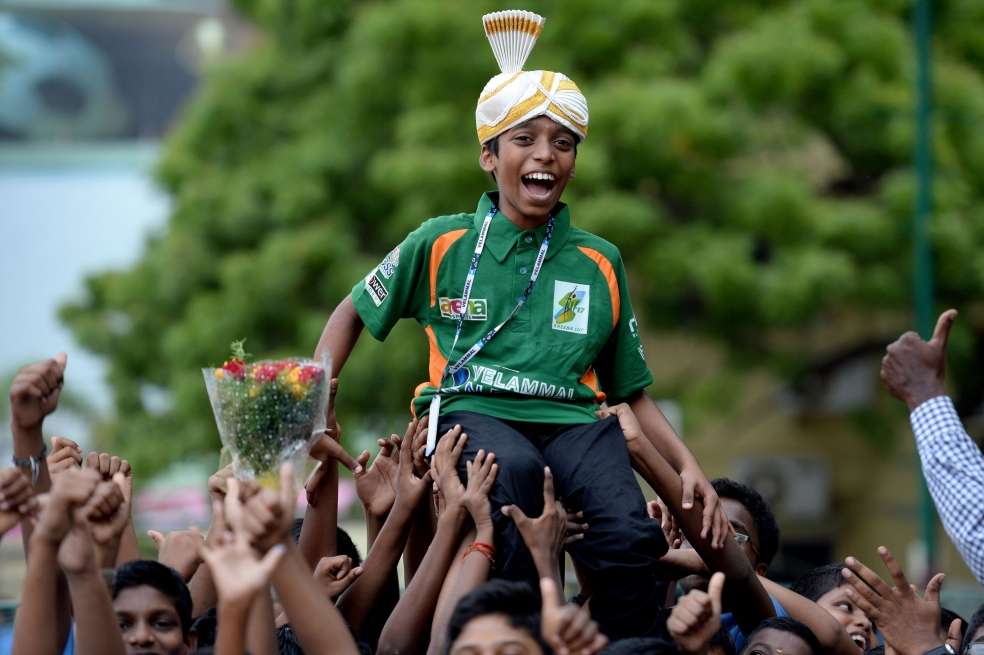 El niño prodigio es sostenido por decenas de personas que celebran su título. / AFP