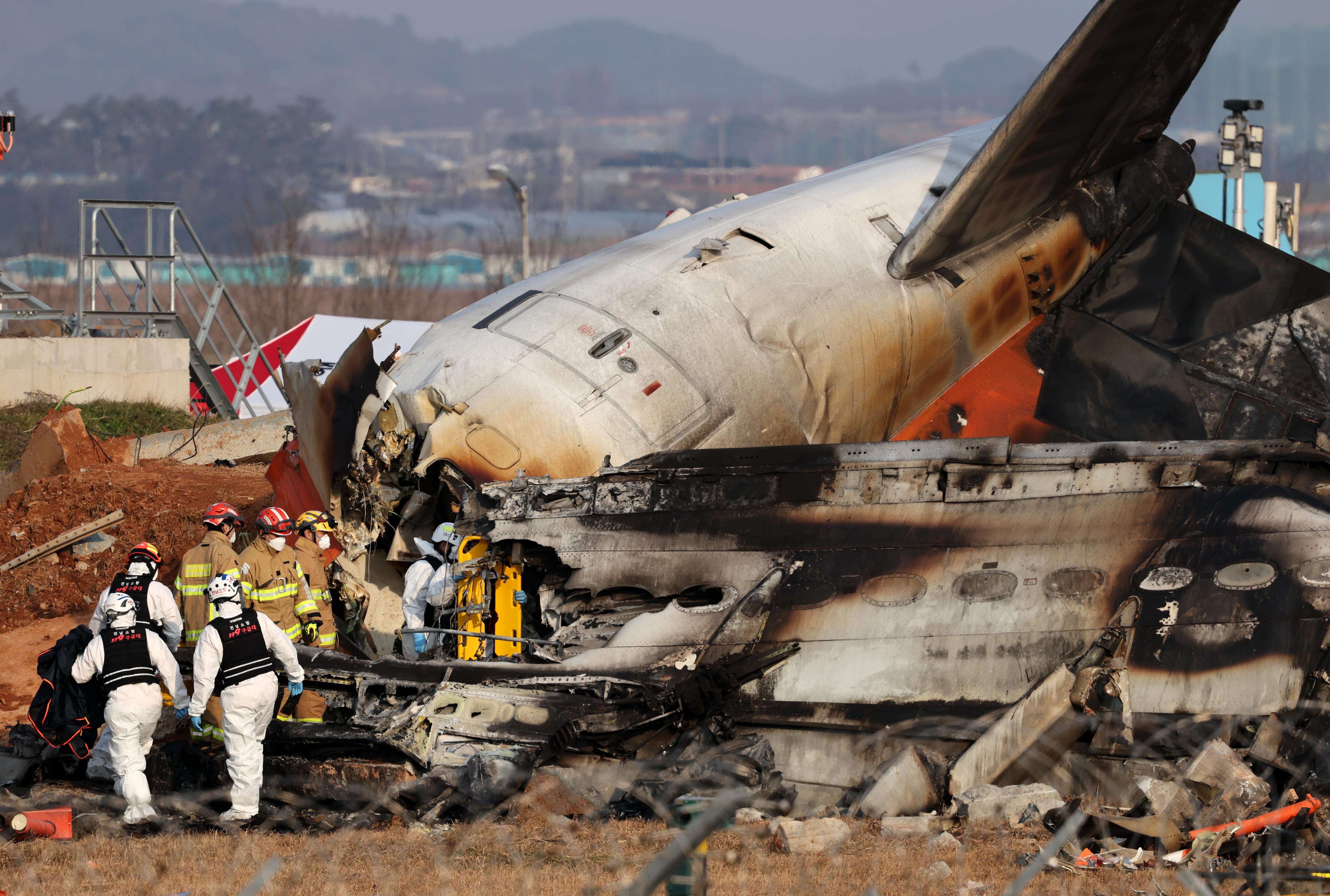 FOTODELDÍA Muan (Corea del Sur), 29/12/2024.- Los bomberos trabajan en los restos del avión Jeju Air en el Aeropuerto Internacional de Muan, 29 de diciembre de 2024 . Las autoridades elevaron a 176 la cifra oficial de muertos en el accidente del avión comercial que se salió de la pista y chocó contra un vallado tras aterrizar. EFE/HAN MYUNG-GU