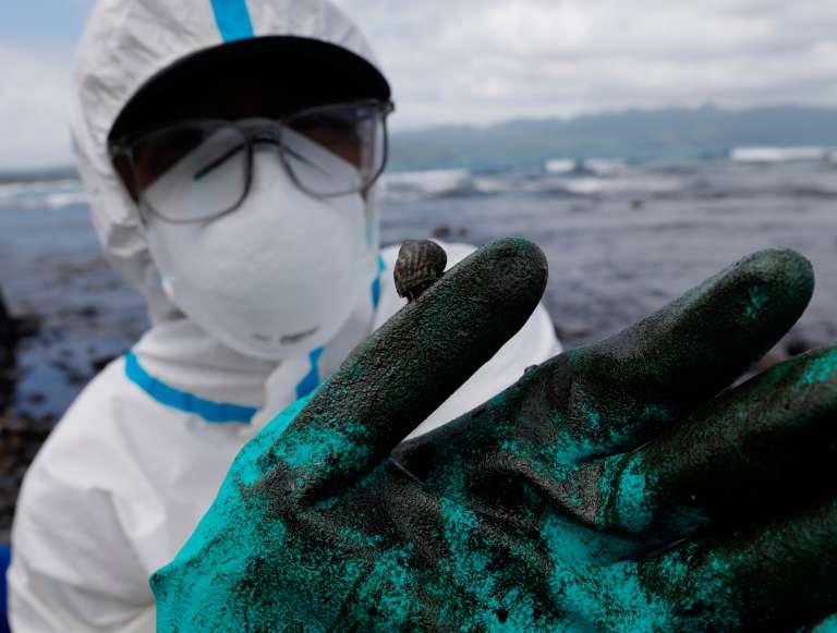 -FOTODELDIA- Pola (Filipinas), 06/03/2023.- Un pescador con un traje protector muestra el vertido de petróleo que asola las costas de Pola, en la isla de Mindoro, Filipinas este lunes. Las autoridades filipinas temen que el vertido tóxico, que ya ha llegado varias islas del centro del archipiélago tras el hundimiento de un carguero el pasado martes, pueda afectar a la isla de Boracay, el destino turístico más importante del país. EFE/ Francis R. Malasig