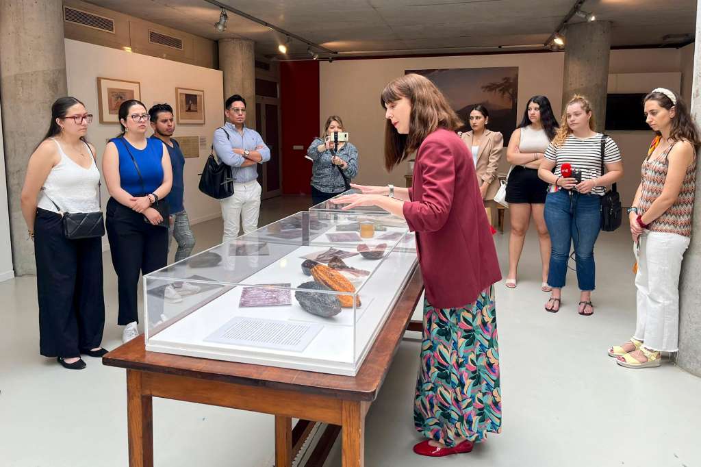 MADRID, 07/06/2024.-Vanessa Quintanar, una de las comisarias de la exposición, explica uno de los exhibidores a los visitantes este viernes en el Real Jardín Botánico-CSIC de Madrid, que acoge en la exposición "Una planta de otro mundo", que explica la historia, la ciencia, la cultura y el arte del cacao en Ecuador y la labor de los científicos por dar a conocer esta especie natural en Europa. EFE/ Aitana González