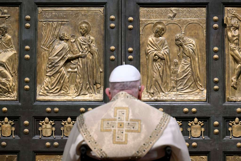 ROMA, 25/12/2024.- El papa Francisco, sentado en su silla de ruedas, llamó con el puño a la Puerta Santa de la basílica de San Pedro que se abrió ante él en total silencio, en un gesto con el que se inaugura el Jubileo, el evento de la Iglesia católica que se celebra cada 25 años y que estará dedicado a la esperanza. Francisco no empujó la puerta como se había hecho anteriormente, sólo golpeó, y quedó sólo en oración ante una basílica de San Pedro en la oscuridad mientras en la plaza sonaban las campanas, después recorrió en la silla de ruedas el pasillo hacia al altar pasando delante de la impresionante Piedad de Miguel Ángel y comenzó la Misa del Gallo. EFE/ Mario Tomassetti/Vatican Media SOLO USO EDITORIAL/SOLO DISPONIBLE PARA ILUSTRAR LA NOTICIA QUE ACOMPAÑA (CRÉDITO OBLIGATORIO)