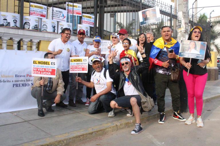 AME6443. LIMA (PERÚ), 06/12/2025.- Personas sostienen carteles durante la marcha "por la paz y la libertad" en Venezuela este sábado, en Lima (Perú). EFE/ Paula Bayarte