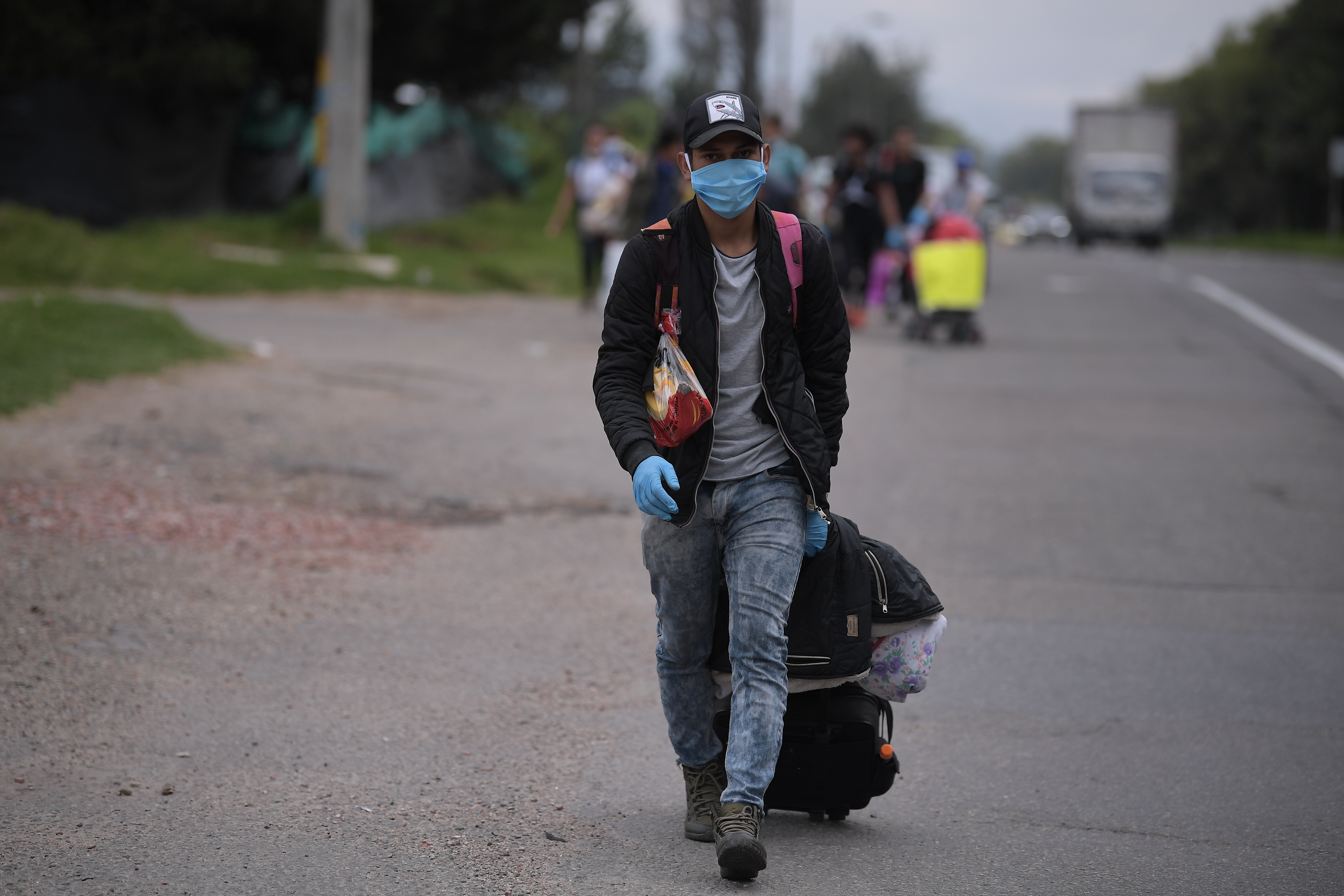 Migrantes venezolanos transitan por la autopista norte de Bogotá de regreso a Venezuela, en medio de la cuarentena obligatoria por cuenta del Covid-19.