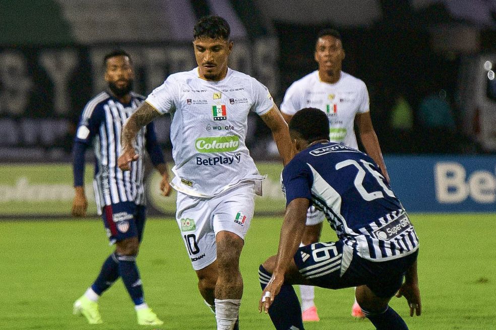 Lucas Ríos, de Once Caldas, conduce la pelota ante la marca de Jhon Navia (Junior).