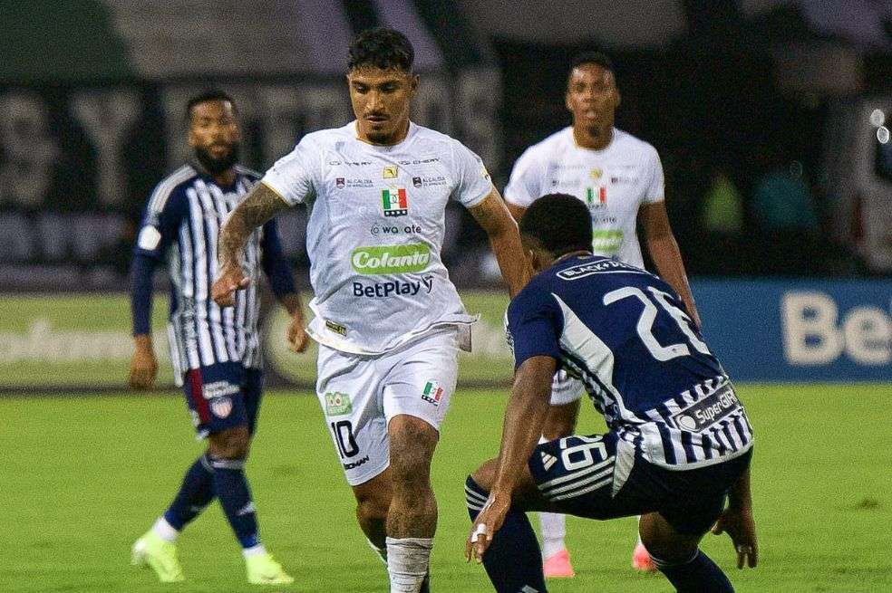 Lucas Ríos, de Once Caldas, conduce la pelota ante la marca de Jhon Navia (Junior).