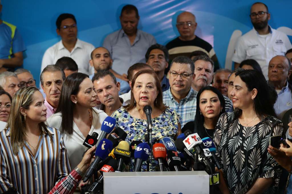 AME1083. CARACAS (VENEZUELA), 22/03/2024.- La historiadora Corina Yoris (c) habla luego de ser presentada como la candidata para las elecciones presidenciales del próximo 28 de julio, en vista de la inhabilitación que impide competir a la líder antichavista María Corina Machado (izq.), durante una rueda de prensa este viernes, en Caracas (Venezuela). En declaraciones a la prensa, Machado aseguró que la decisión "surgió del seno de la discusión de las fuerzas unitarias" y forma parte de un mecanismo acordado para hacer "frente a este obstáculo", en referencia a su inhabilitación, ratificada en enero por el Tribunal Supremo de Justicia (TSJ), una sanción a la calificó como "un acto írrito, totalmente inconstitucional y cobarde". EFE/ Rayner Peña R.