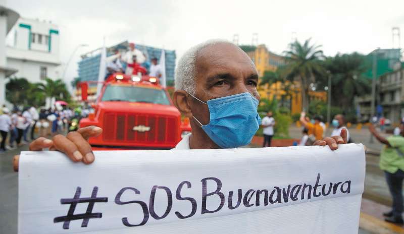 AME4719. BUENAVENTURA (COLOMBIA), 10/02/2021. Un hombre marcha con una pancarta durante una protesta contra la violencia, hoy en Buenaventura (Colombia). Miles de personas se unieron este miércoles en una cadena humana para clamar por la paz en Buenaventura, principal puerto de Colombia en el Pacífico y donde la violencia ha provocado en las últimas semanas una oleada de desplazamiento. EFE/ Ernesto Guzmán Jr.
