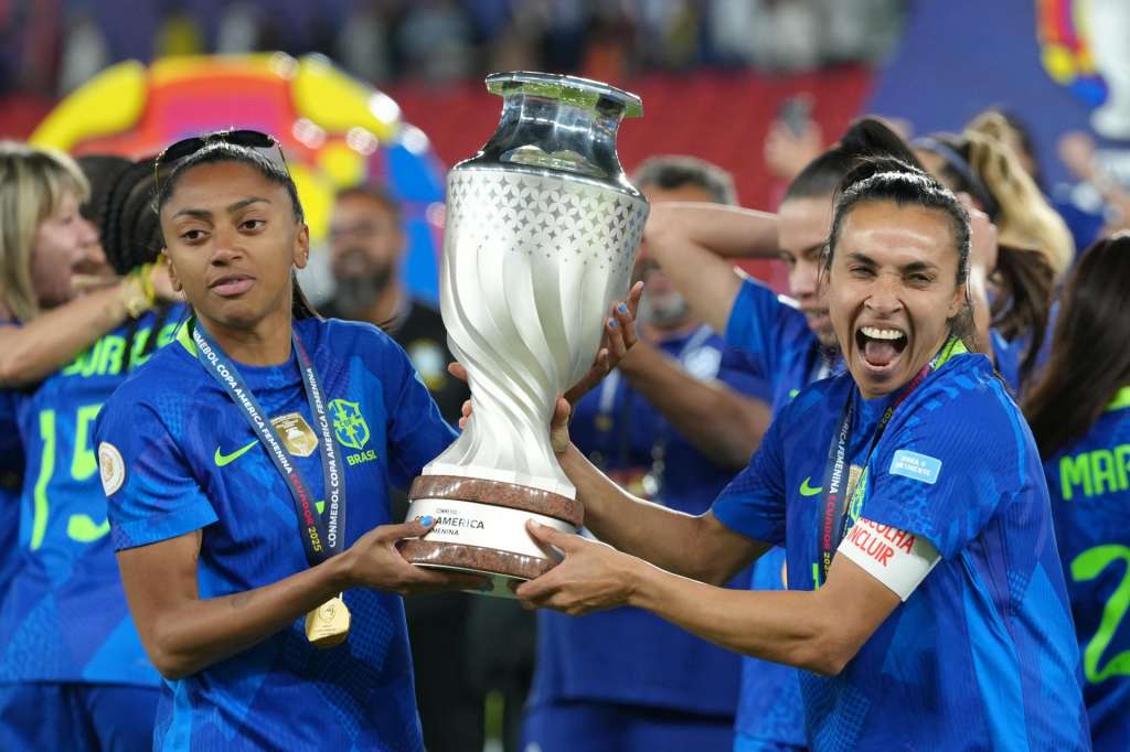 AMDEP9575. QUITO (ECUADOR), 02/08/2025.- Kerolin (i) y Marta Vieira da Silva de Brasil sostienen el trofeo de la Copa América Femenina este sábado, luego de vencer a Colombia en la final en el estadio Rodrigo Paz Delgado en Quito (Ecuador). EFE/ Vicente Costales