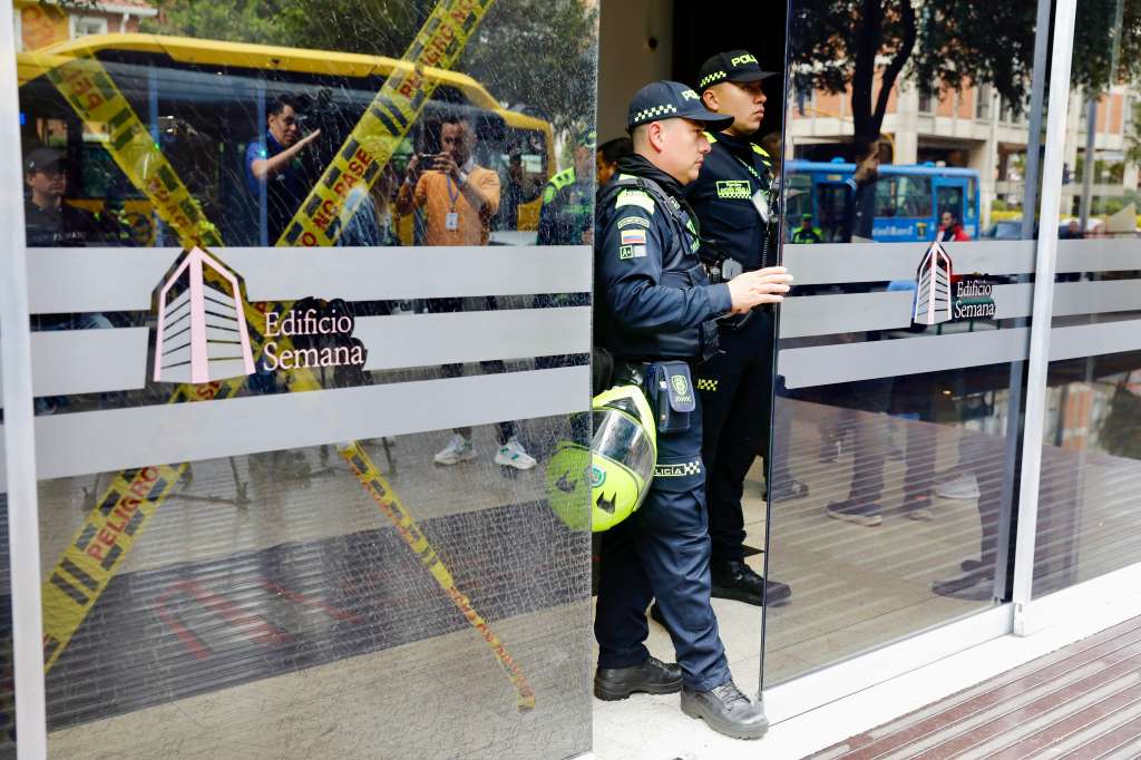 AME3569. BOGOTÁ (COLOMBIA), 29/09/2023.- Integrantes de la Policía permanecen en la entrada del edificio donde funciona la revista Semana, hoy, en Bogotá (Colombia). Un grupo de indígenas entró este viernes a la fuerza a las instalaciones en Bogotá de la revista Semana, crítica del Gobierno colombiano, donde causaron destrozos en un vidrio de la entrada del edificio e intimidaron a las personas que allí se encontraban. Así lo denunció la directora de la revista, Vicky Dávila, quien aseguró que pidió ayuda a la Policía porque "un grupo grande de indígenas rompió vidrios en el edificio de Semana e ingresó a la fuerza". EFE/ Carlos Ortega