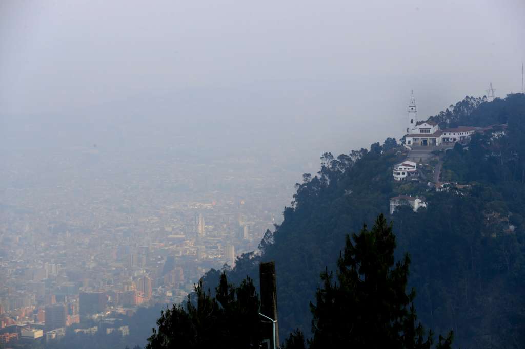 BOG400. BOGOTÁ (COLOMBIA), 27/01/2024.- Vista hoy del cerro de Monserrate (d) bajo una capa de humo producida por los incendios de los cerros orientales de Bogotá (Colombia). Frente a los incendios que golpean a la capital colombiana, el alcalde Carlos Fernando Galán anunció medidas como una alerta zonal por deterioro de la calidad del aire en el suroccidente de la ciudad, así como extender la medida de pico y placa -que restringe el tránsito de vehículos- a los sábados. EFE/ Carlos Ortega
