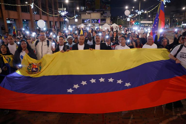 AME6464. BOGOTÁ (COLOMBIA), 06/12/2025.- Personas sostienen una bandera durante la marcha "por la paz y la libertad" en Venezuela, en conmemoración al Nobel de la Paz el 10 de diciembre a la líder antichavista María Corina Machado, este sábado, en Bogotá (Colombia). EFE/ Mauricio Dueñas Castañeda