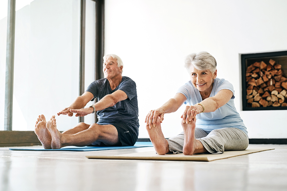 Pareja de adultos mayores en casa haciendo ejercicio
