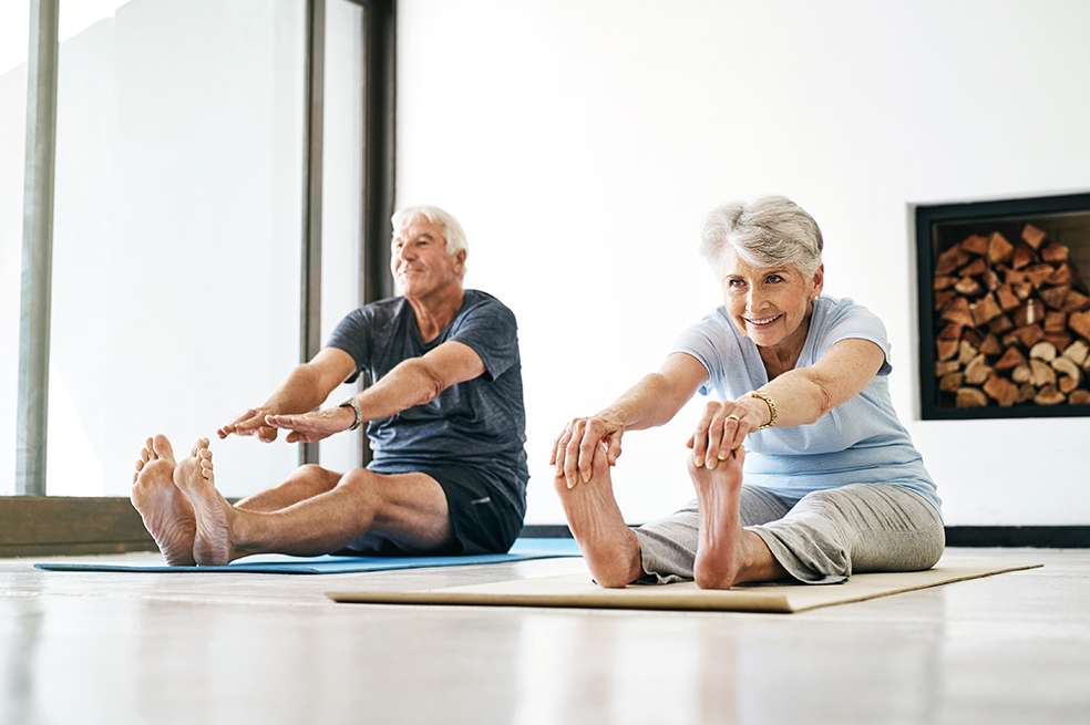Abuelos y adultos mayores realizan yoga en casa por el confinamiento Shot of a senior couple practising yoga together at home