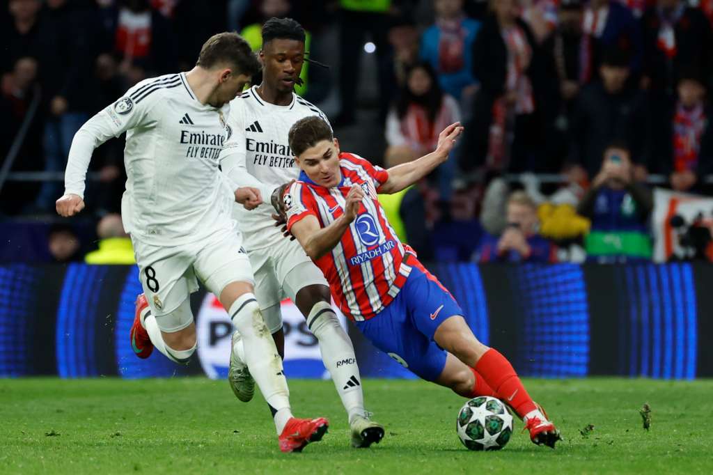 MADRID, 12703/2025.- El delantero argentino del Atlético de Madrid, Julián Álvarez (d), intenta llevarse el balón ante los jugadores del Real Madrid, el uruguayo Federico Valverde (i) y el francés Eduardo Camavinga, durante el partido de vuelta de los octavos de final de la Liga de Campeones que Atlético de Madrid y Real Madrid disputan este miércoles en el estadio Metropolitano. EFE/Juanjo Martín
