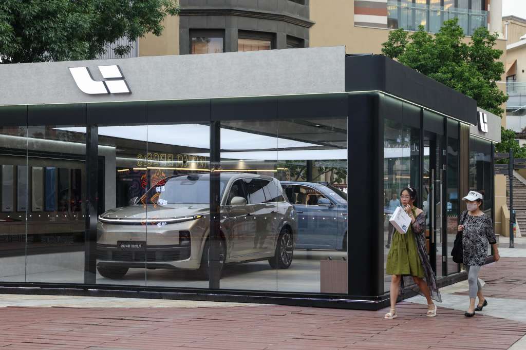 Beijing (China), 13/06/2024.- People walk beside a NIO electric car showroom in Beijing, China, 13 June 2024. Beijing urges the European Union to reconsider tariffs on Chinese electric vehicles and to stop going further in what they say is the 'wrong direction' to protect its auto industry from competition, according to China's state news agency Xinhua. China said it would take measures to safeguard its interests after the European Commission announced on 12 June it would impose extra duties of up to 38.1 percent on imported Chinese electric vehicles from July 2024. EFE/EPA/WU HAO
