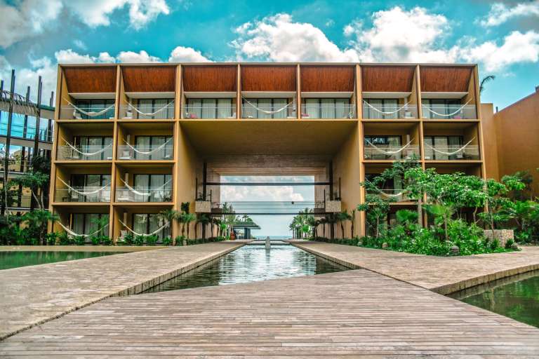 Con un diseño exterior que recuerda a los antiguos templos y pirámides mayas con ventanales contemporáneos del piso al techo y amplias terrazas frente al mar. Cada una de las 63 suites tiene personalidad propia y están divididas en 3 edificios: Natural, Fiesta y Wellness.