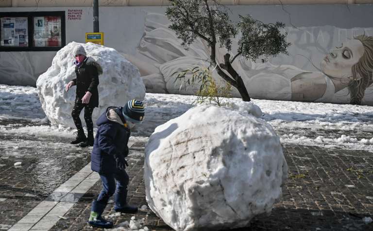 Niños juegan con la nieve, que en otras partes de la ciudad afectó el tráfico.