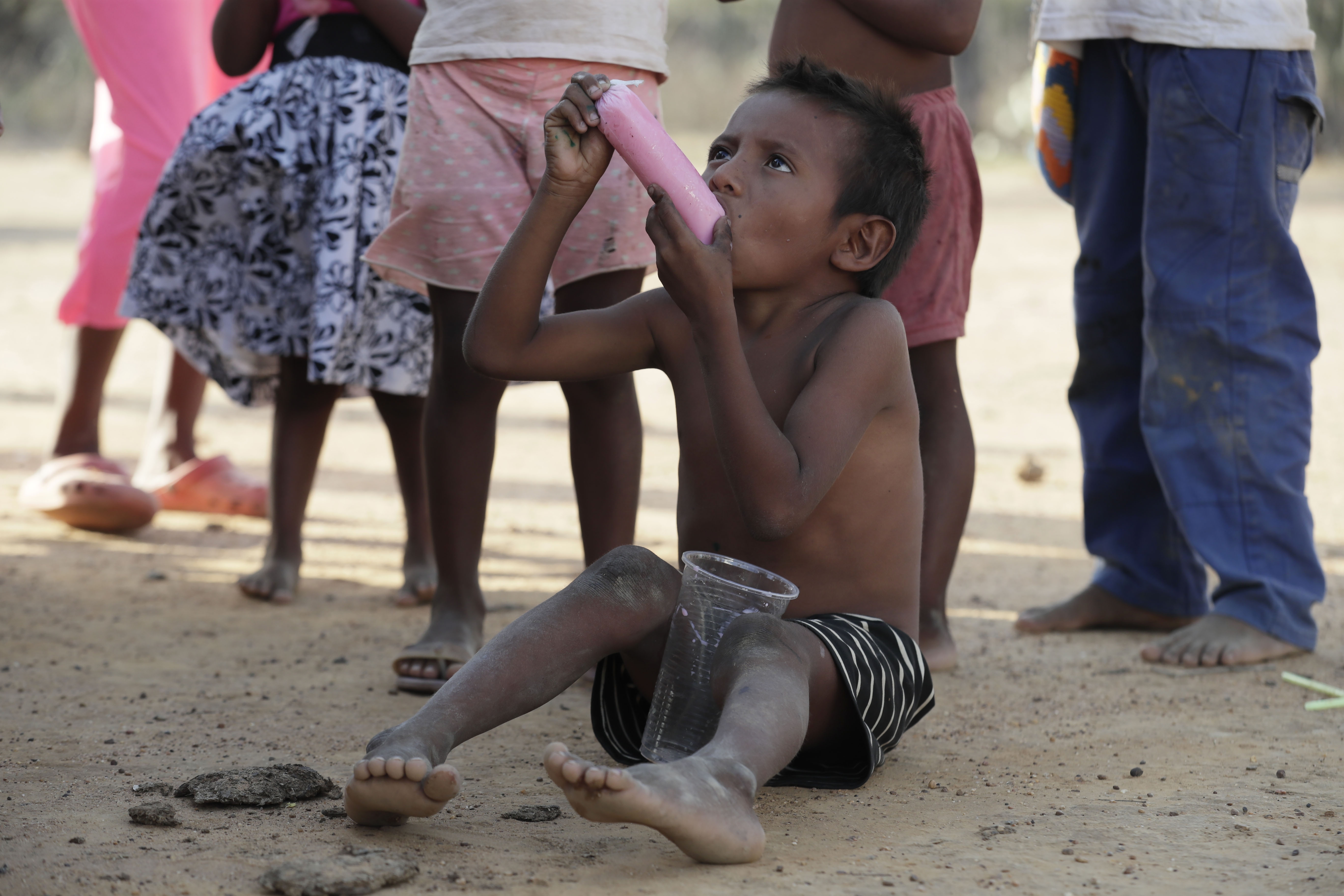 AME5255. RIOHACHA (COLOMBIA), 25/07/2023.- Fotografía de archivo fechada el 14 de mayo de 2022 que muestra un niño indígena wayúu mientras come hielo saborizado en la comunidad Witka, en zona rural de Manaure (Colombia). La muerte por desnutrición de los indígenas wayúu ya hace parte del paisaje desértico del departamento colombiano de La Guajira, fronterizo con Venezuela, una zona en donde viven cerca de 800.000 personas que hoy ven cómo las condiciones climáticas se agravan por el fenómeno de El Niño. EFE/ Carlos Ortega ARCHIVO