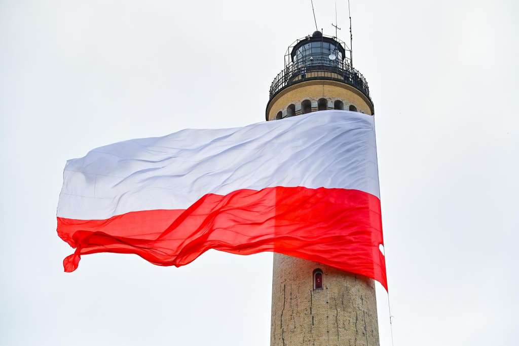 FOTODELDÍA SWINOUJSCIE (POLONIA), 02/05/2025.- La considerada como la bandera de Polonia más grande del mundo, con una superficie de 400 metros cuadrados, ondea en el faro de Swinoujscie por undécima vez, con motivo de la celebración del Día de la Bandera polaca, este viernes. EFE/ Marcin Bielecki / PROHIBIDO SU USO EN POLONIA