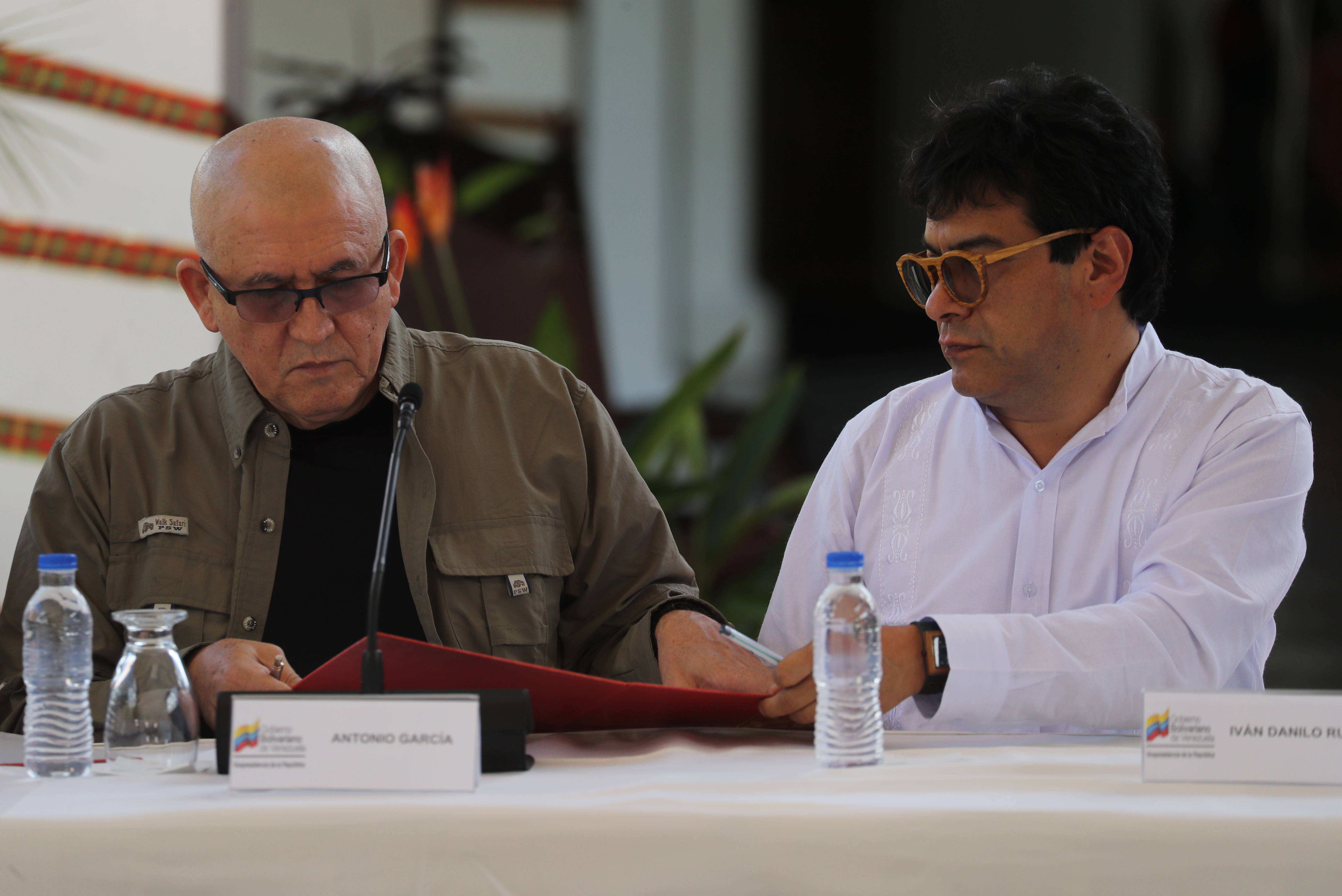 AME2111. CARACAS (VENEZUELA), 04/10/2022.- El vocero del Ejército de Liberación Nacional Antonio García (i) y el vocero del Gobierno de Colombia Iván Danilo Rueda (d) firman un acuerdo durante una reunión hoy, en Caracas (Venezuela). La guerrilla del Ejército de Liberación Nacional (ELN) y el Gobierno de Colombia retomarán las negociaciones de paz el próximo noviembre, según un acuerdo firmado este martes por las partes en Venezuela, país que actuará como garante en los diálogos, junto a Cuba y Noruega. EFE/ Miguel Gutiérrez