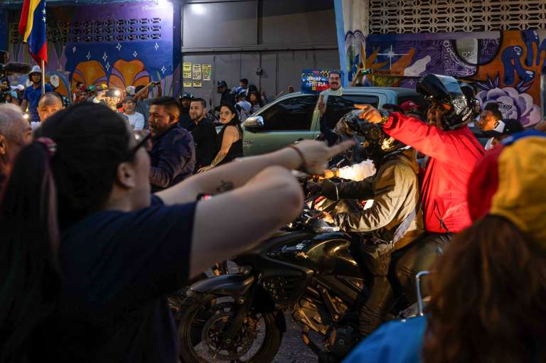 AME6017. CARACAS (VENEZUELA), 28/07/2024.- Seguidores del presidente de Venezuela y candidato a la reelección, Nicolás Maduro, se enfrentan desde una caravana de motocicletas con personas este domingo, en Caracas (Venezuela). Varias decenas de motorizados que se identificaron como chavistas llegaron a un centro de votación en Caracas, donde se encontraban testigos opositores y ciudadanos que esperaban el comienzo del escrutinio de las elecciones presidenciales de este domingo, lo que dio lugar a una confrontación que acabó a golpes, ante la mirada impasible de los policías, que no intervinieron para detener la pelea. EFE/ Henry Chirinos