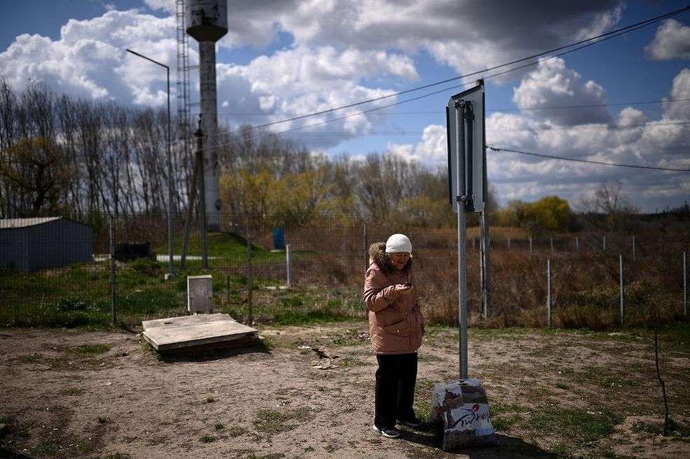 Una anciana ucraniana refugiada sostiene su teléfono mientras espera cruzar la frontera entre Ucrania y Moldavia.
